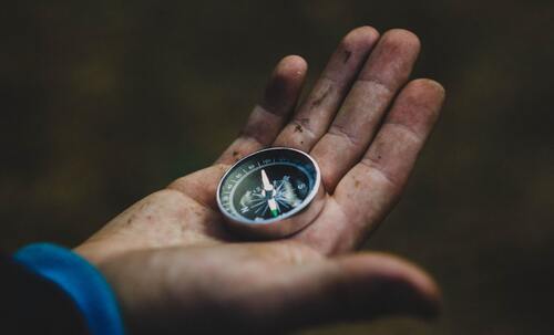 Suche nach einer Webdesign-Agentur, visualisiert durch einen Kompass in einer Hand
